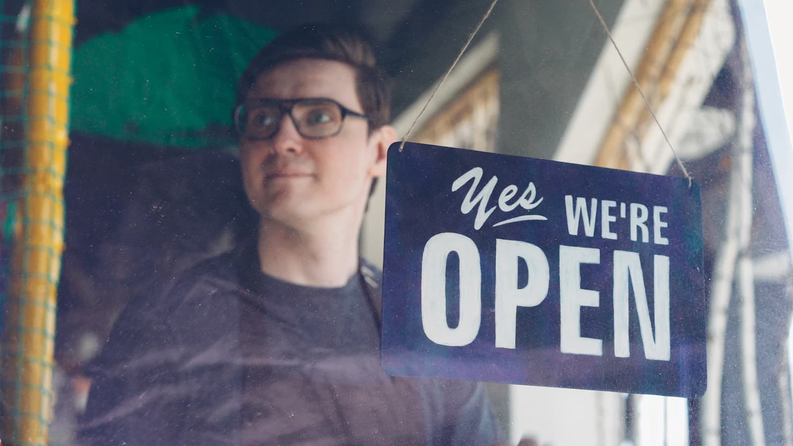 MKB-ondernemer trots met open-bord voor zijn winkel — kleine ondernemer met AI-chatbot